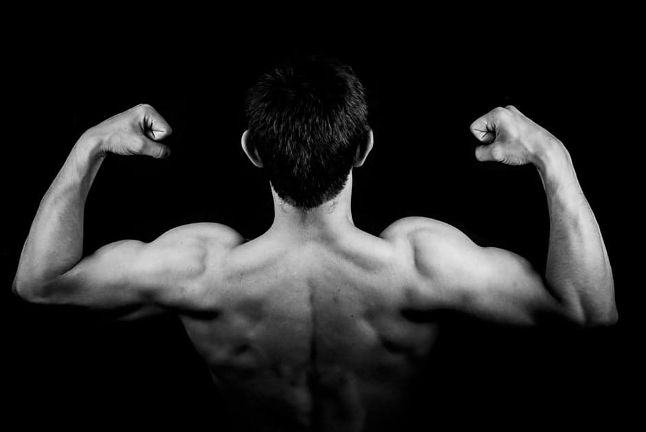 man back building muscle in dark
